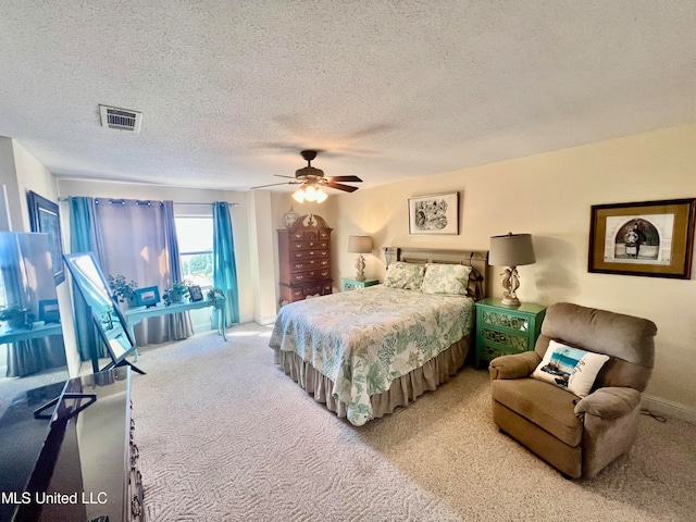 bedroom featuring ceiling fan, a textured ceiling, and carpet floors