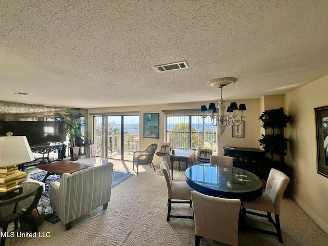 dining room featuring a notable chandelier, carpet, and a textured ceiling