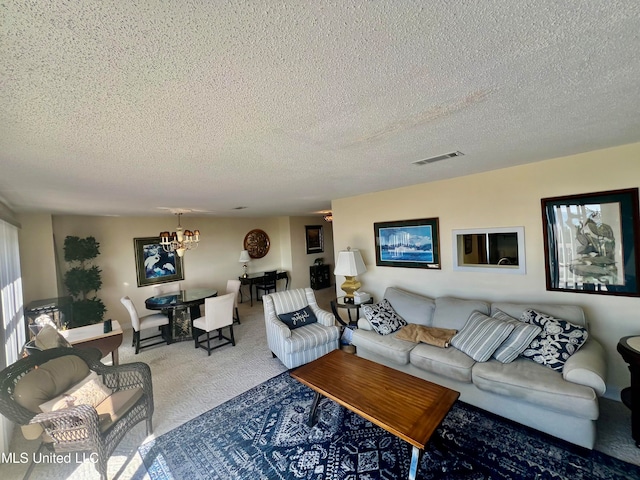 living room with carpet, a notable chandelier, and a textured ceiling