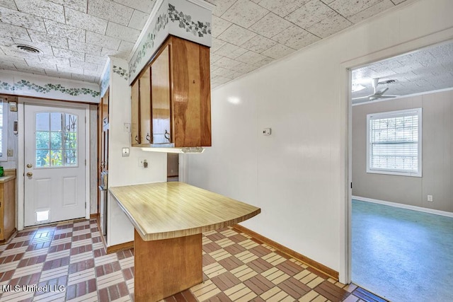 20332 Red Bird Hill Rd, Gulfport, MS 39503 - kitchen with plenty of natural light, brown cabinetry, light countertops, baseboards, and ornamental molding