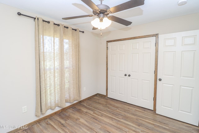 unfurnished bedroom with a closet, light wood-type flooring, and ceiling fan