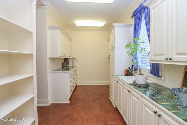 interior space featuring tile countertops, ornamental molding, white cabinets, and dark carpet