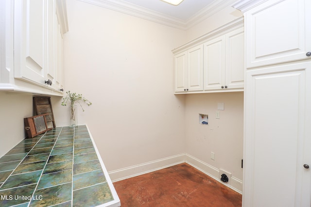 washroom with hookup for a washing machine, crown molding, and cabinets