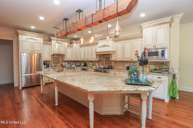 kitchen with a spacious island, built in appliances, a kitchen bar, and dark hardwood / wood-style floors