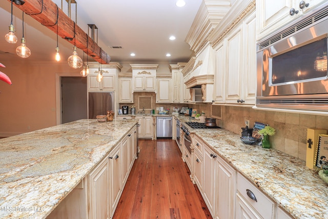 kitchen with ornamental molding, hanging light fixtures, stainless steel appliances, dark wood-type flooring, and decorative backsplash