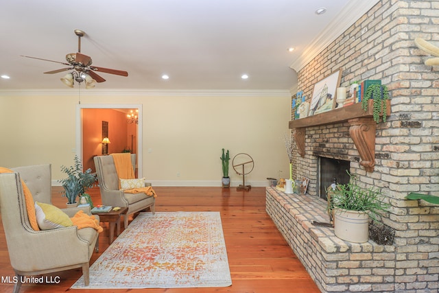 living room with light hardwood / wood-style flooring, ceiling fan, a brick fireplace, and crown molding