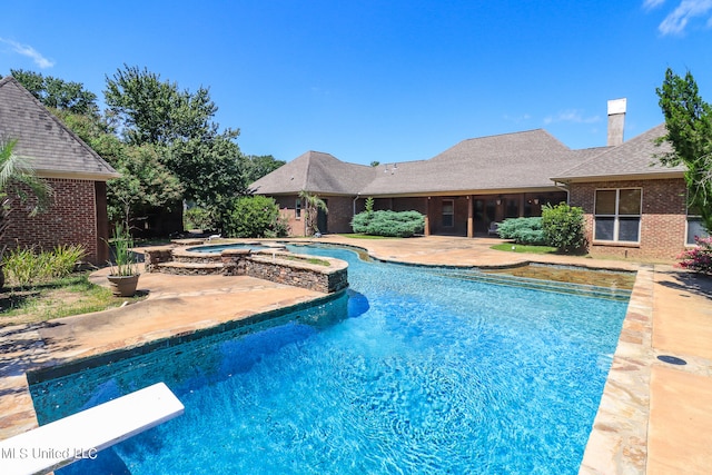 view of swimming pool featuring an in ground hot tub, a patio area, and a diving board