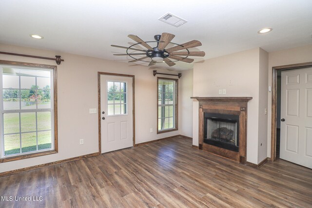 unfurnished living room with dark wood-type flooring and ceiling fan