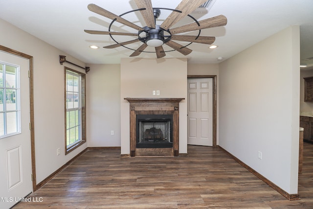 unfurnished living room with dark hardwood / wood-style floors and ceiling fan