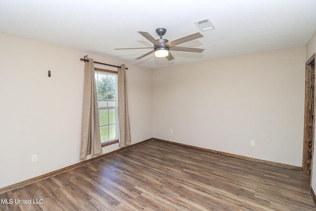 empty room featuring dark wood-type flooring and ceiling fan