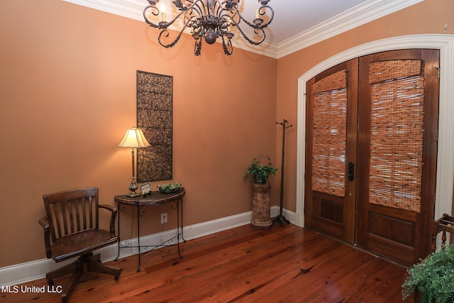 foyer entrance featuring ornamental molding, french doors, dark hardwood / wood-style floors, and a chandelier