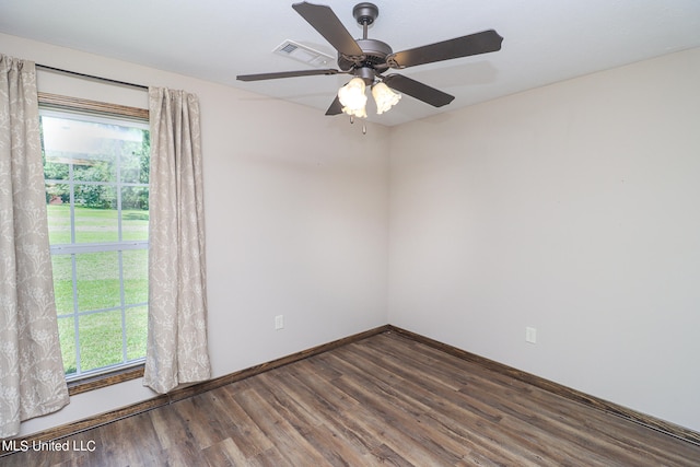 spare room with a wealth of natural light, dark hardwood / wood-style floors, and ceiling fan