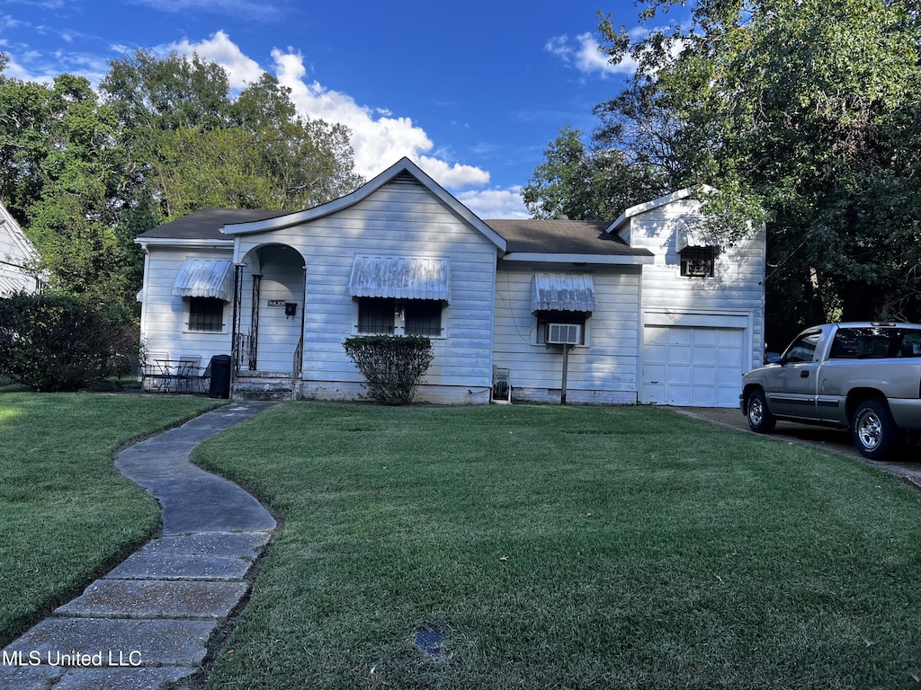 ranch-style house with a front yard, cooling unit, and a garage