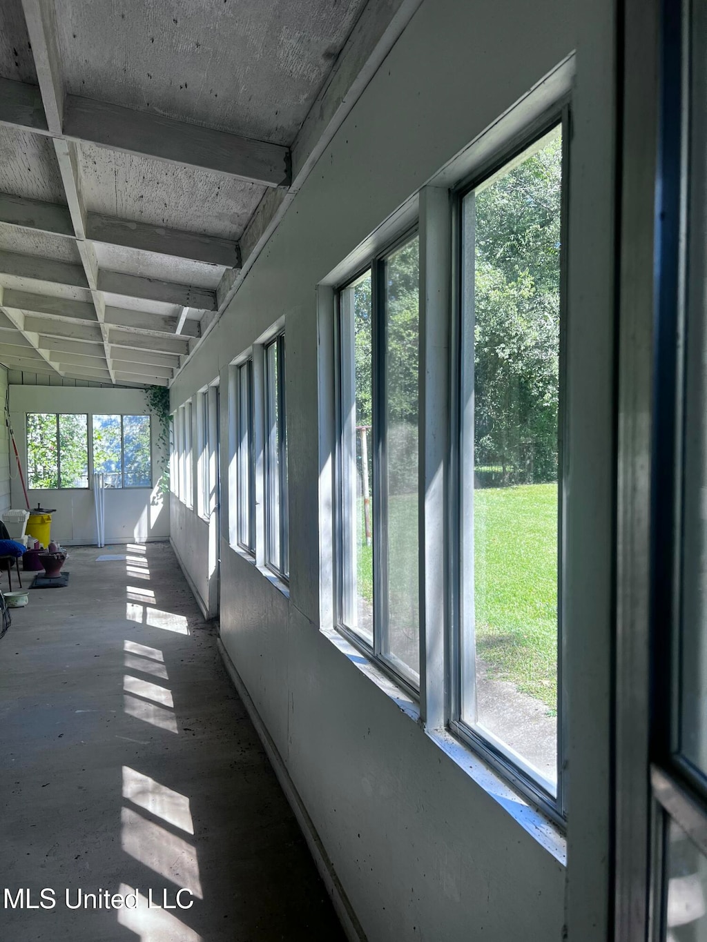 unfurnished sunroom with beamed ceiling