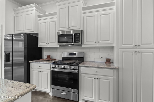 123 Bailey Cv, Canton, MS 39046 - kitchen featuring appliances with stainless steel finishes, crown molding, white cabinets, tasteful backsplash, and light stone counters