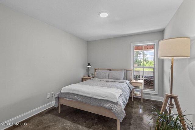 123 Bailey Cv, Canton, MS 39046 - bedroom with baseboards and concrete flooring