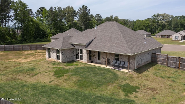 123 Bailey Cv, Canton, MS 39046 - rear view of property with brick siding, a patio area, a shingled roof, and view of wooded area