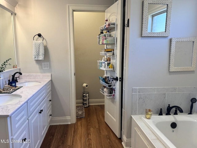 4 Bayou Ln, Natchez, MS 39120 - bathroom featuring a bath, wood finished floors, baseboards, and a sink
