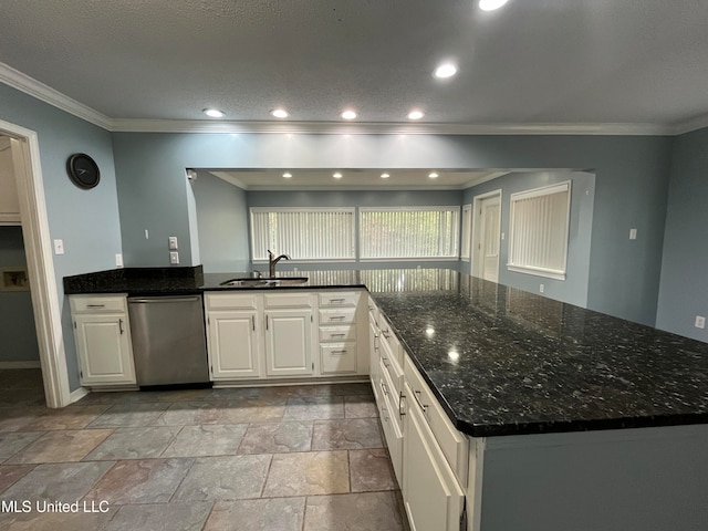 kitchen with dishwasher, dark stone countertops, ornamental molding, sink, and white cabinetry