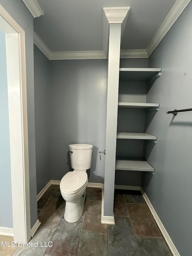 bathroom featuring crown molding and toilet