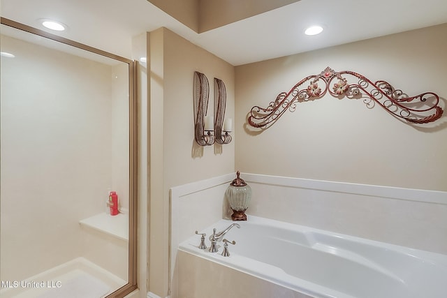 bathroom featuring a stall shower, a bath, and recessed lighting