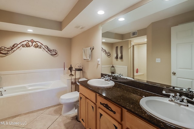 bathroom with tile patterned floors, a garden tub, recessed lighting, double vanity, and toilet