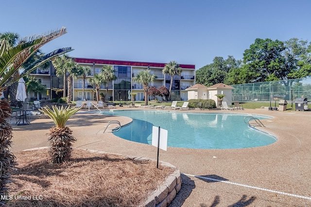 community pool featuring a patio area and fence