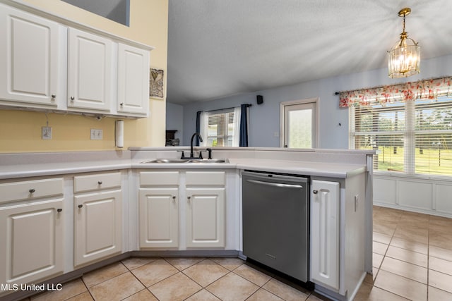 kitchen featuring kitchen peninsula, white cabinetry, stainless steel dishwasher, decorative light fixtures, and sink