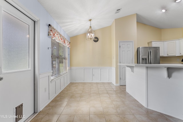 1602 Heather Ct, Ocean Springs, MS 39564 - kitchen with white cabinets, a breakfast bar area, light countertops, stainless steel refrigerator with ice dispenser, and visible vents
