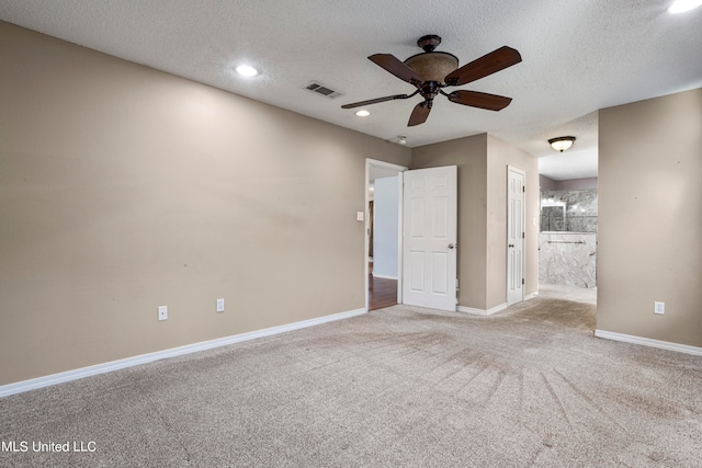 carpeted spare room featuring a textured ceiling and ceiling fan