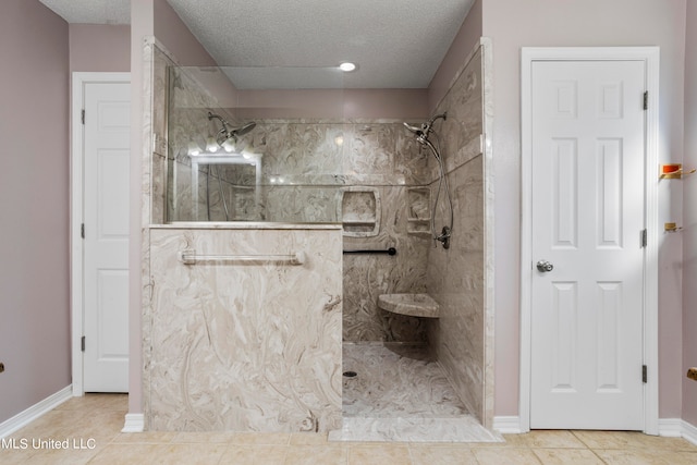 bathroom featuring tile patterned flooring, a textured ceiling, and tiled shower