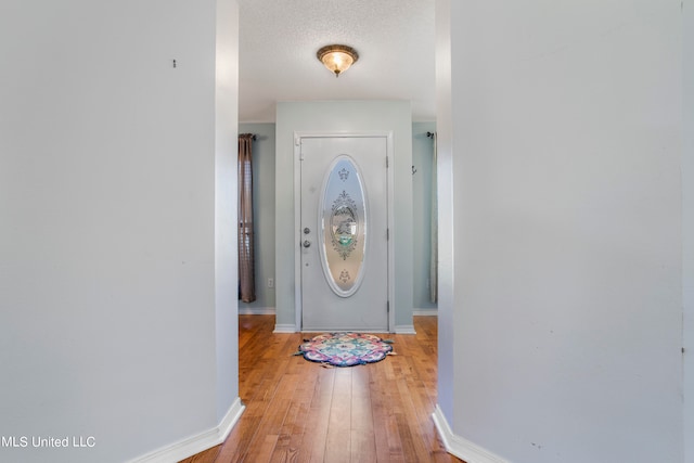 entryway featuring hardwood / wood-style flooring and a textured ceiling