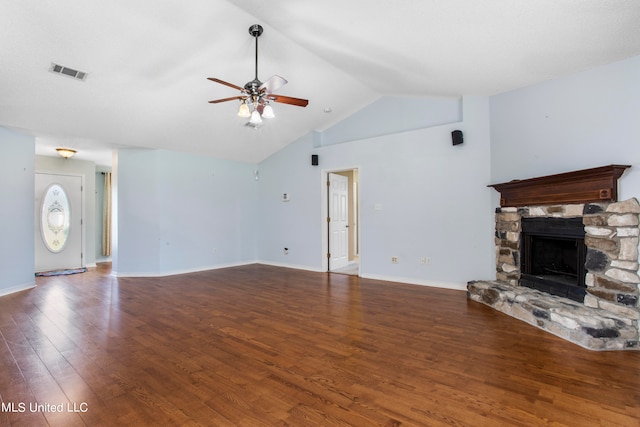 unfurnished living room featuring lofted ceiling, ceiling fan, a stone fireplace, and dark hardwood / wood-style flooring