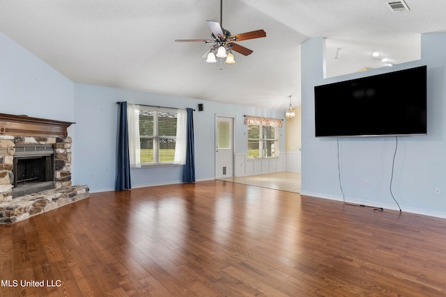 unfurnished living room featuring lofted ceiling, hardwood / wood-style floors, and a fireplace