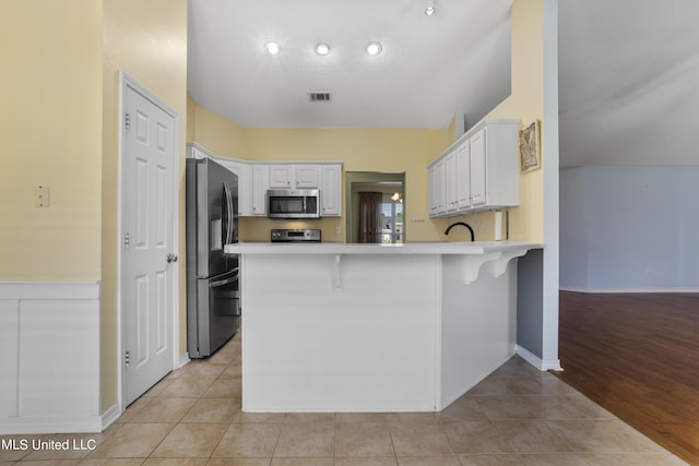 1602 Heather Ct, Ocean Springs, MS 39564 - kitchen with visible vents, light countertops, a peninsula, stainless steel appliances, and white cabinetry