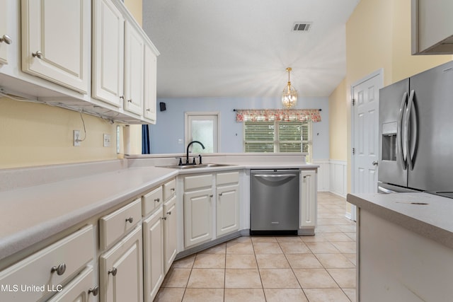 kitchen featuring white cabinetry, appliances with stainless steel finishes, sink, and hanging light fixtures