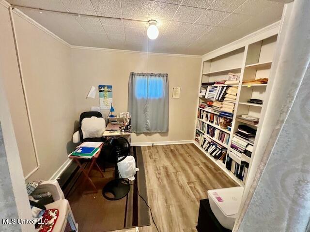 office featuring wood finished floors, crown molding, and baseboards