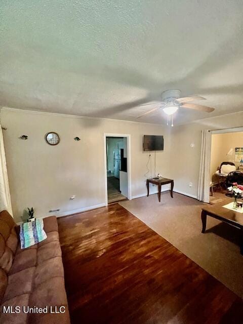 unfurnished living room with wood finished floors, a textured ceiling, a ceiling fan, and baseboards