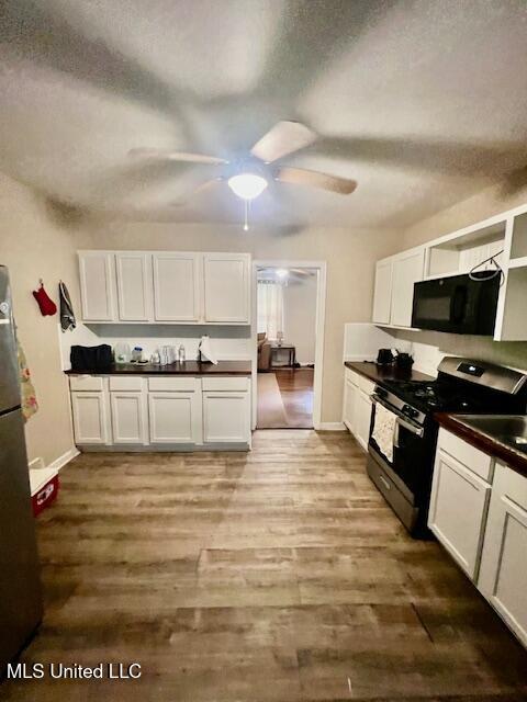 kitchen with white cabinets, dark countertops, ceiling fan, and stainless steel appliances