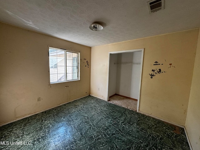 unfurnished bedroom with a closet and a textured ceiling