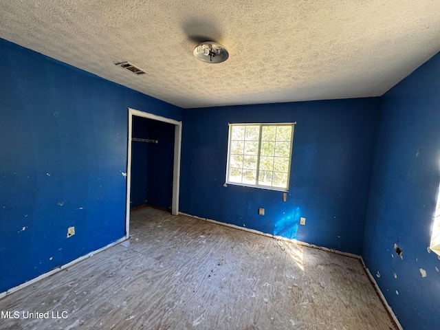 unfurnished bedroom with a closet and a textured ceiling