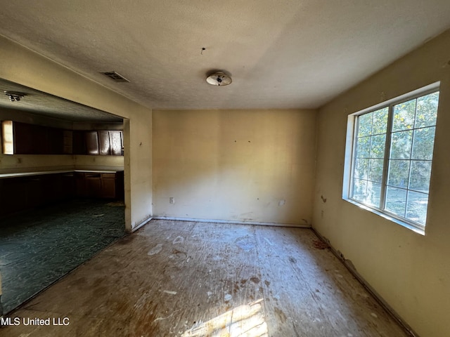 unfurnished dining area with a textured ceiling