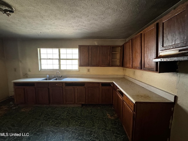 kitchen featuring dark brown cabinetry, a textured ceiling, and sink