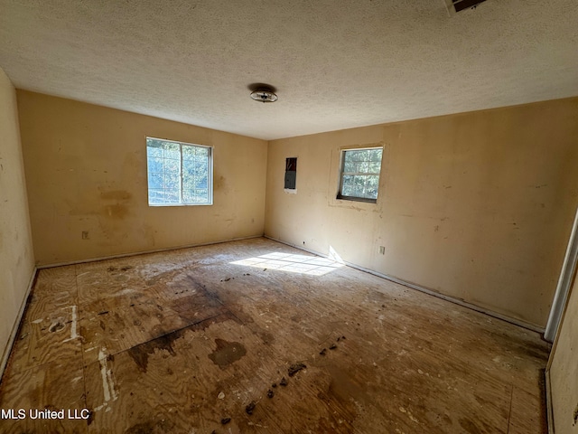 unfurnished room featuring a textured ceiling