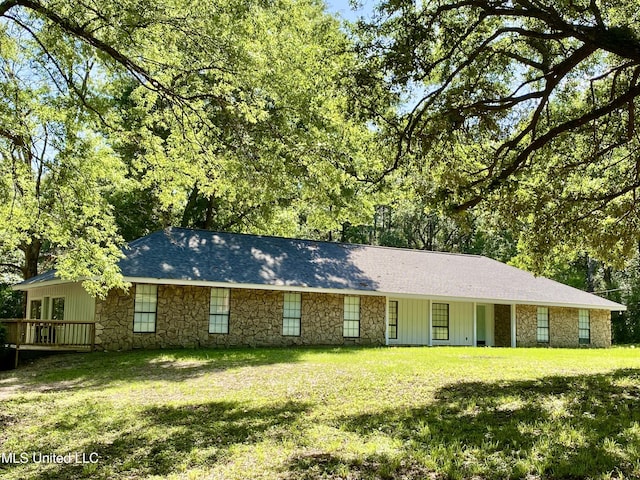 ranch-style home with board and batten siding, a front lawn, and stone siding