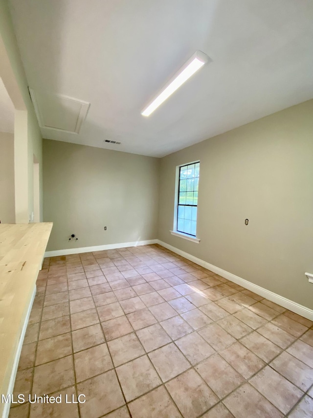 unfurnished room with baseboards, light tile patterned flooring, and visible vents