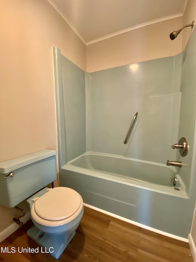 bathroom with ornamental molding, wood finished floors, bathing tub / shower combination, and toilet