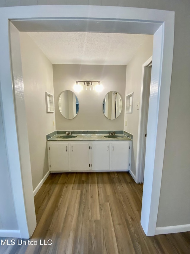 bathroom with baseboards, a sink, and wood finished floors