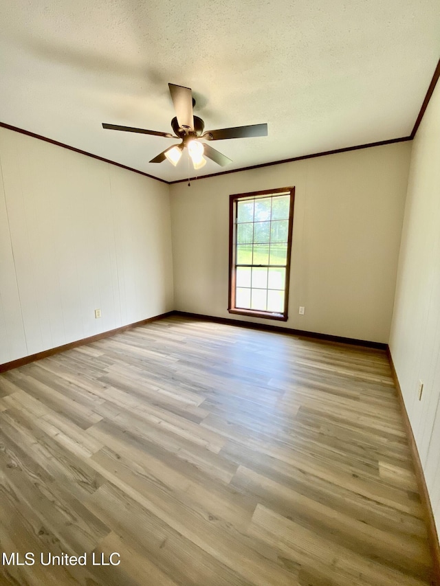 unfurnished room featuring crown molding, baseboards, a ceiling fan, and wood finished floors