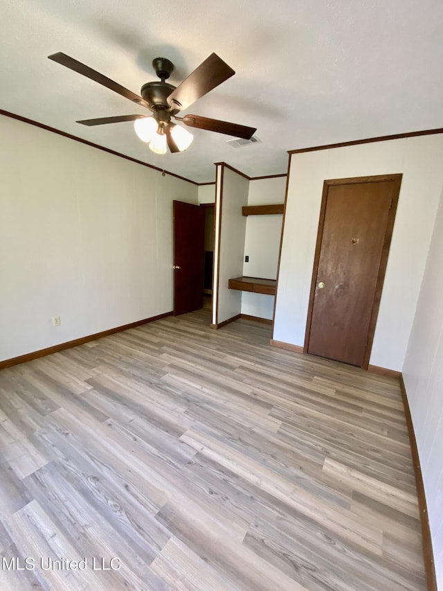 unfurnished bedroom featuring light wood-type flooring, ornamental molding, baseboards, and visible vents